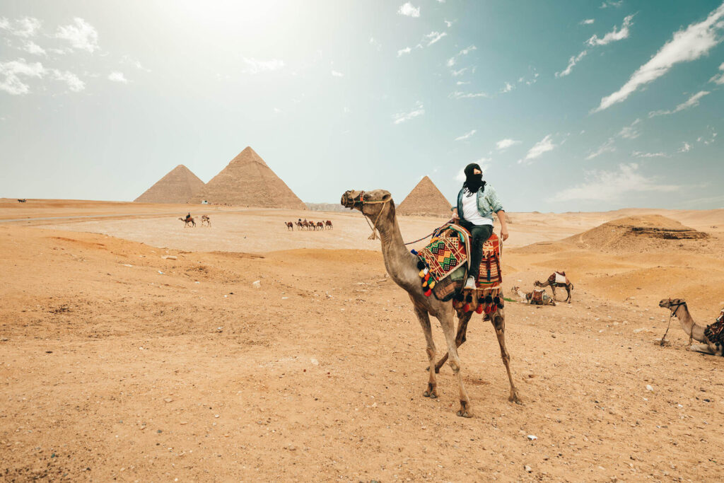 A woman riding a camel near the pyramids in Egypt